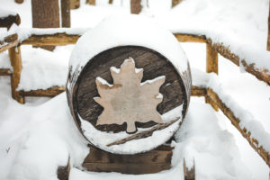 Tonneau avec une feuille d'érable sous la neige au Québec