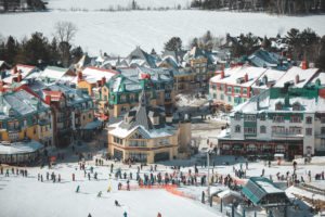 Station du Mont Tremblant et skieurs au Québec vu des pistes